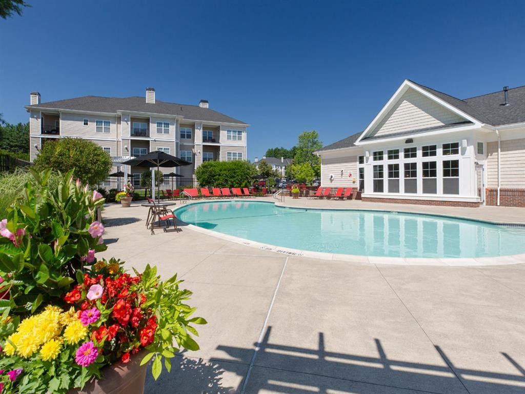 a swimming pool with flowers in front of a building