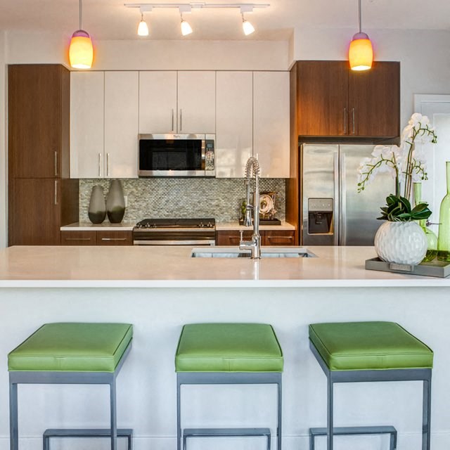 a kitchen with three stools in front of a counter
