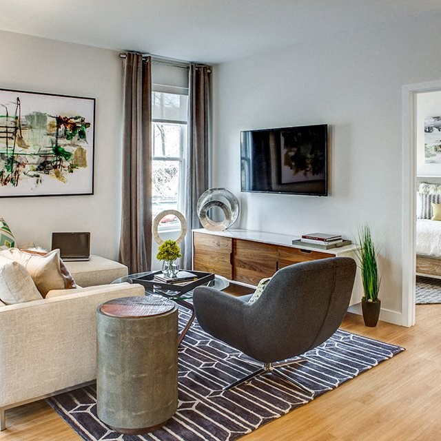 a living room with a couch and a chair and a television