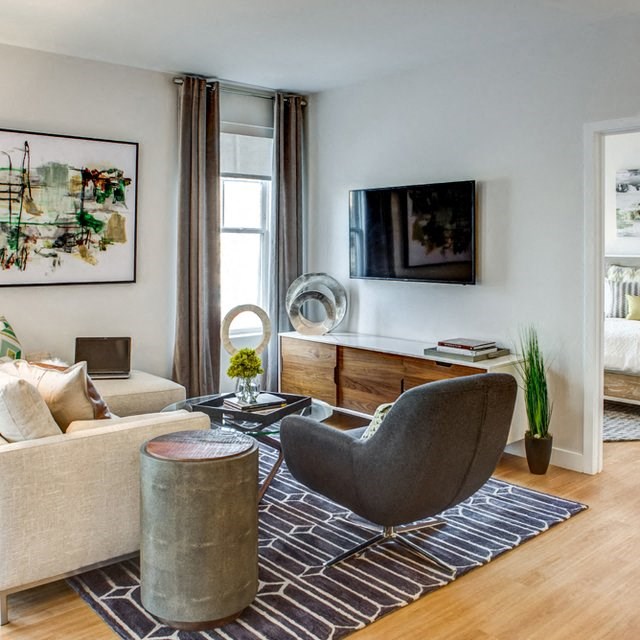 a living room with a couch and a chair and a television