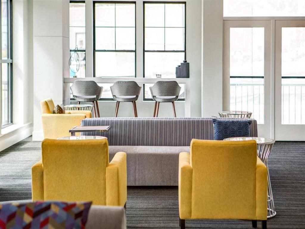 a large living room with yellow chairs and a couch