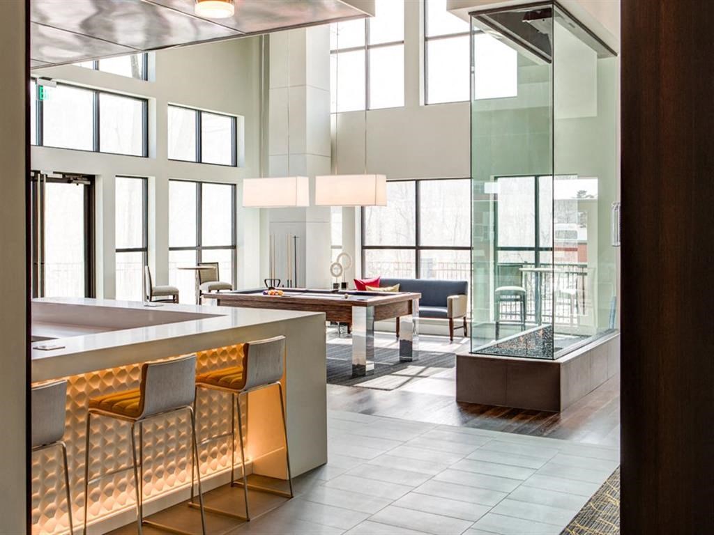 the lobby of a hotel with a bar and a pool