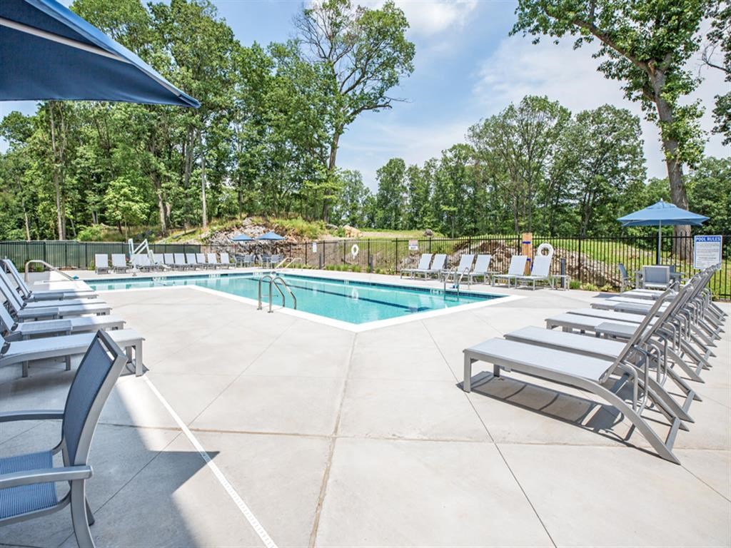 a pool with lounge chairs and chairs around it