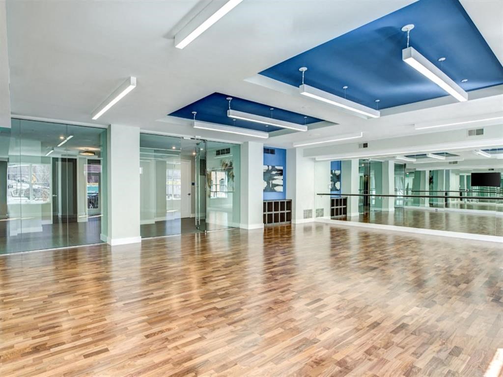 a large room with a hard wood floor and a mirrored ceiling