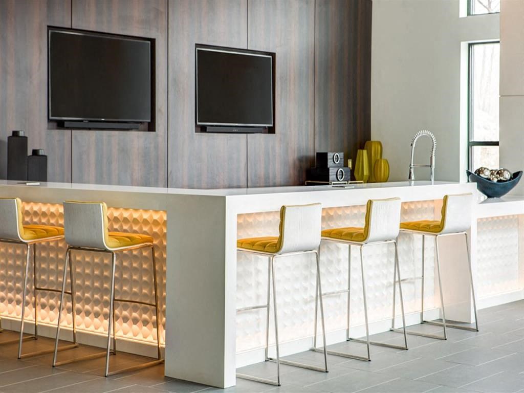 a modern kitchen with bar stools and a television