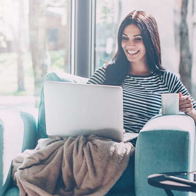a woman sitting in a chair with a laptop