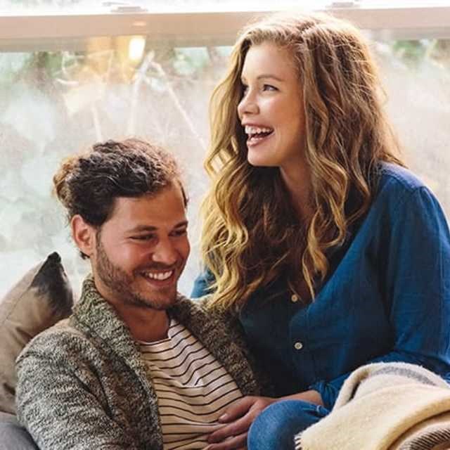 a man and a woman sitting on a couch laughing