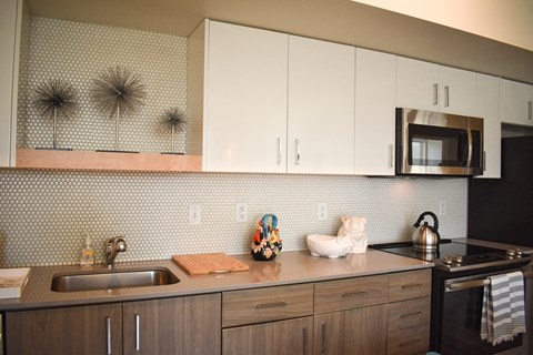 a kitchen with white cabinets and a sink and a microwave