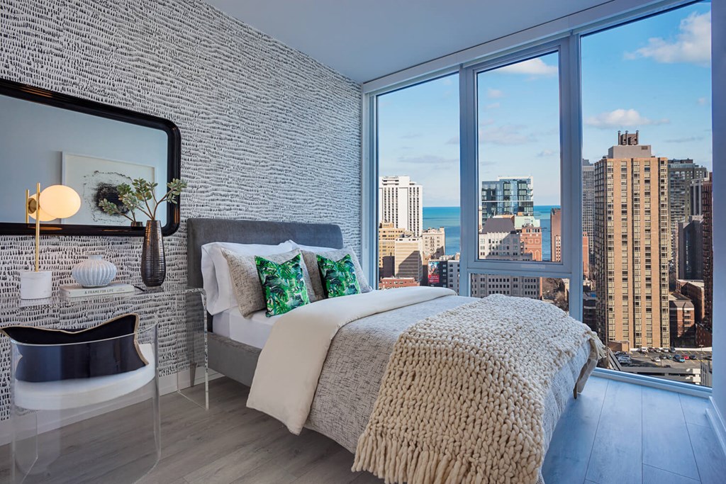 a bedroom with a bed and a view of the city