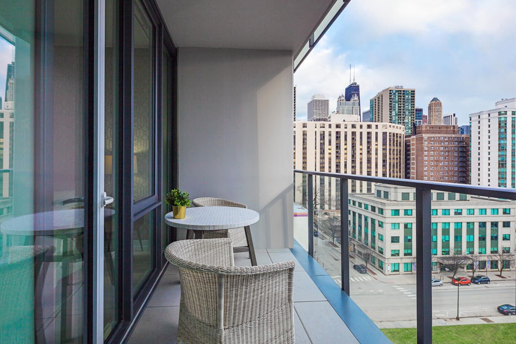 a balcony with a table and chairs and a view of the city