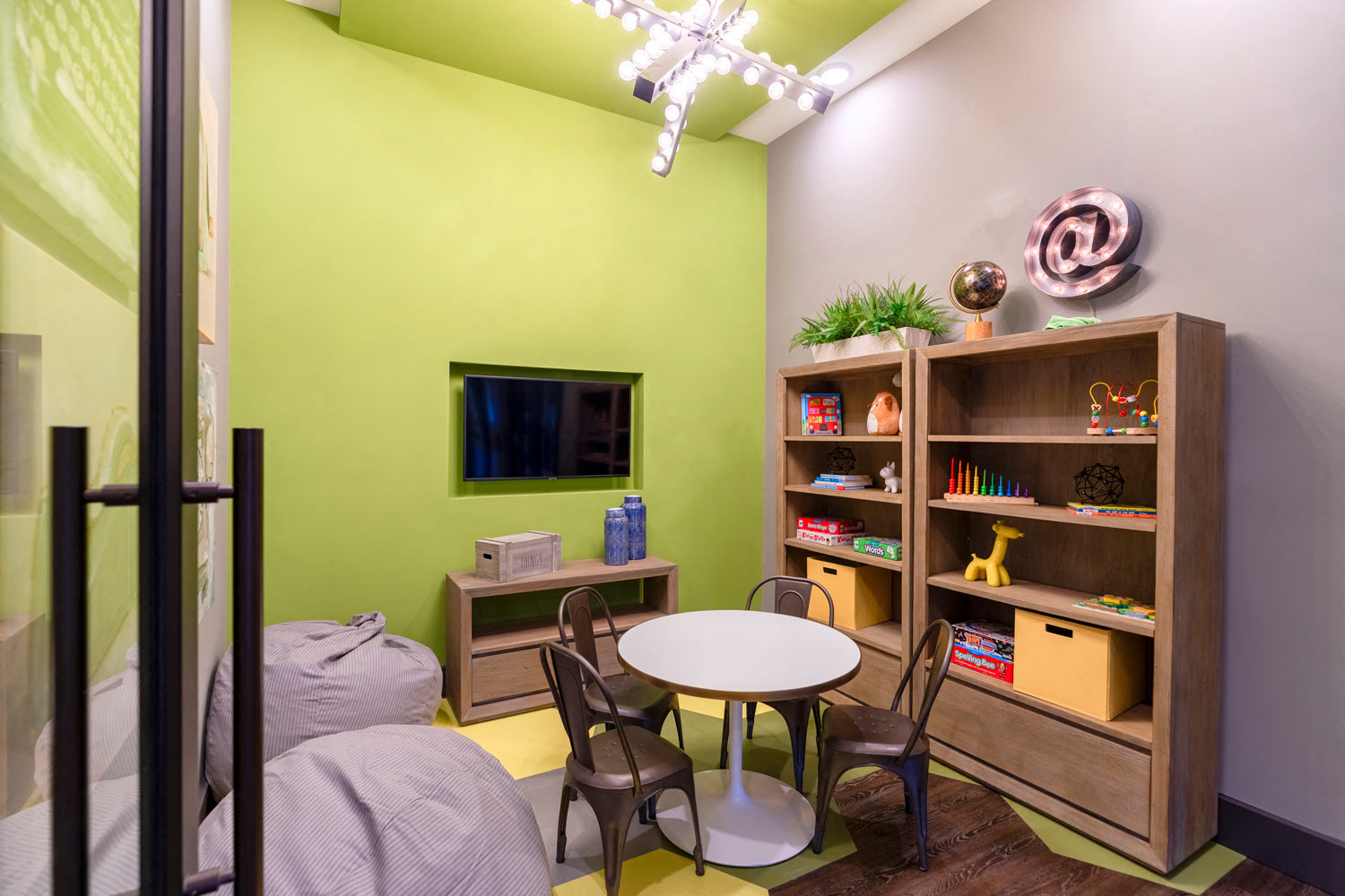 a living room with green walls and a table and chairs