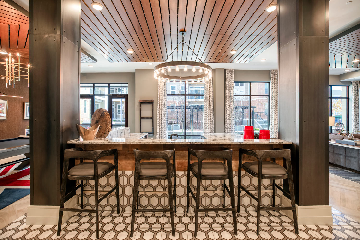 a kitchen with a bar and stools in a lobby