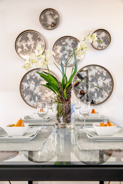 a table with plates and a vase with flowers on it