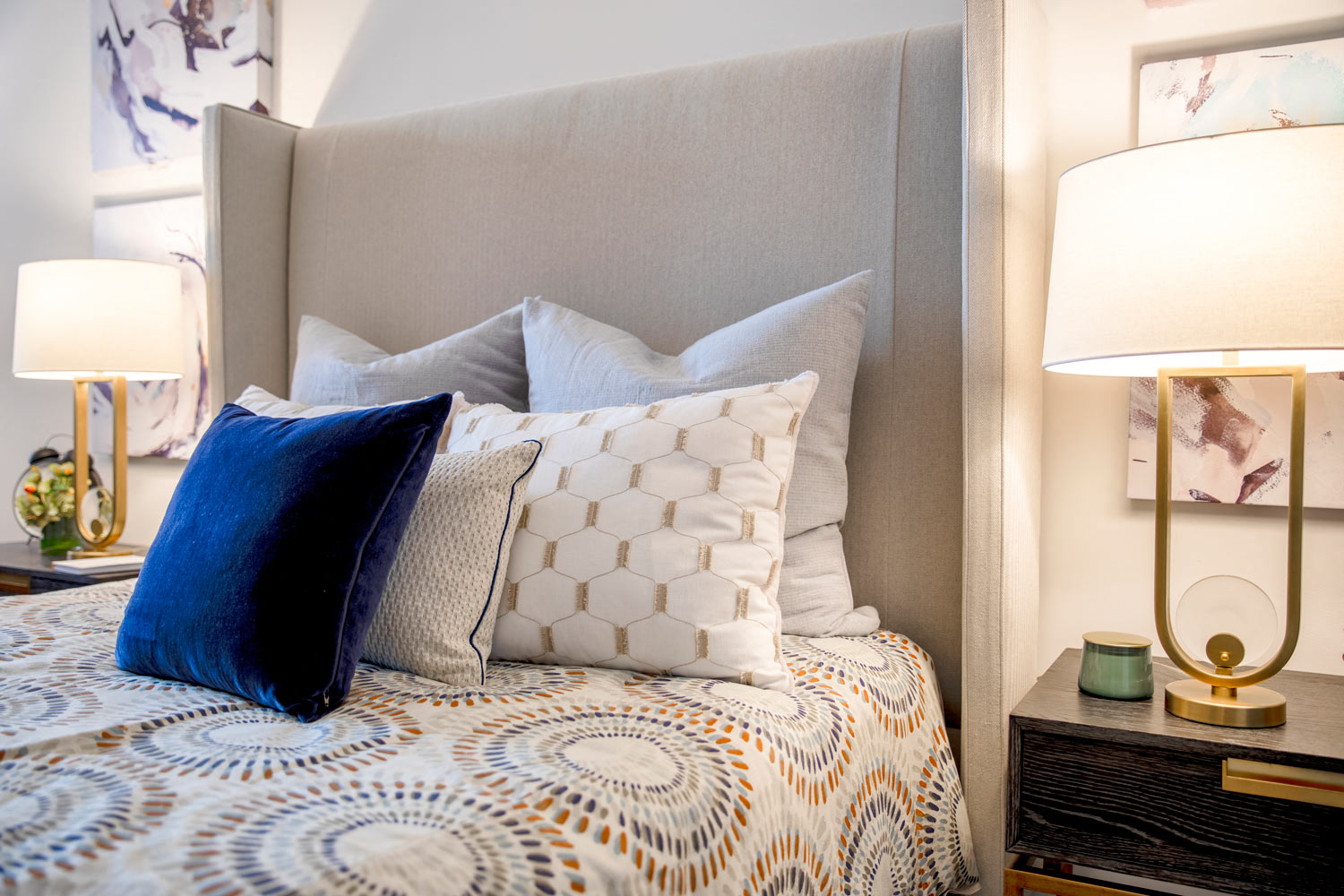 a bedroom with a bed and pillows and two lamps