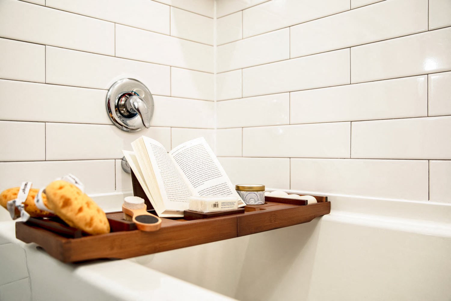 a book on a tray on the edge of a bath tub
