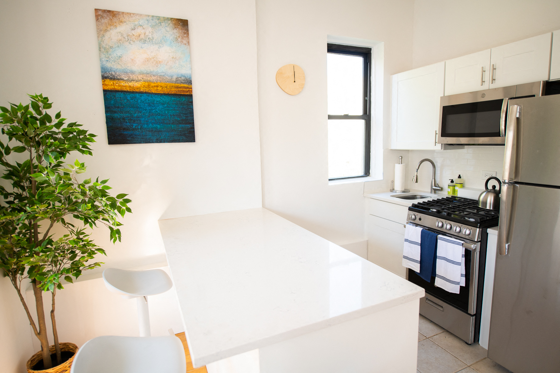 a kitchen with a white counter top and a stainless steel stove