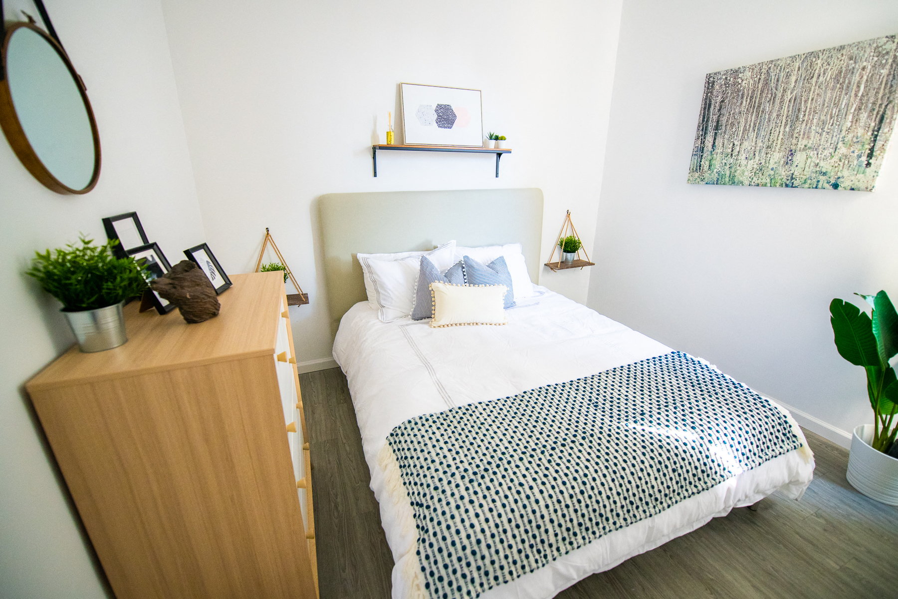 a bedroom with a white bed and a wooden dresser