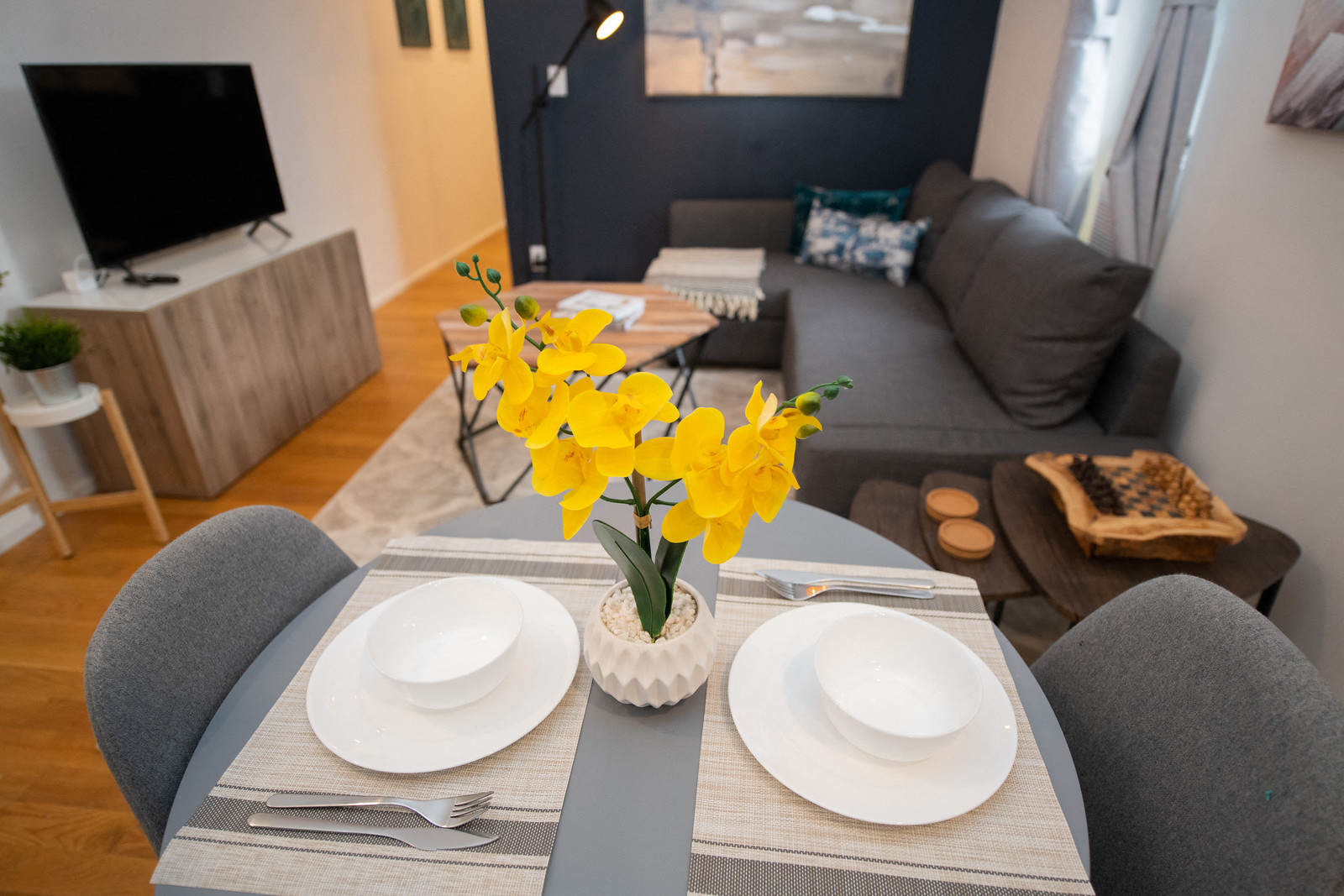 a living room with a dining table with yellow flowers