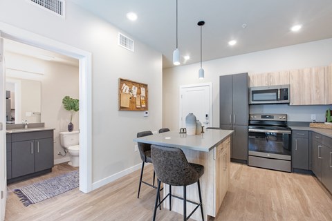 an open kitchen with an island and stools in front of a kitchen counter top