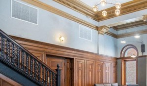 the lobby of a building with a staircase and two doors