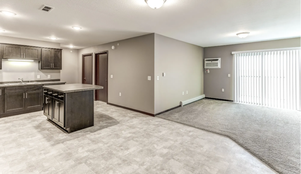 the living room and kitchen of a new home with a large window