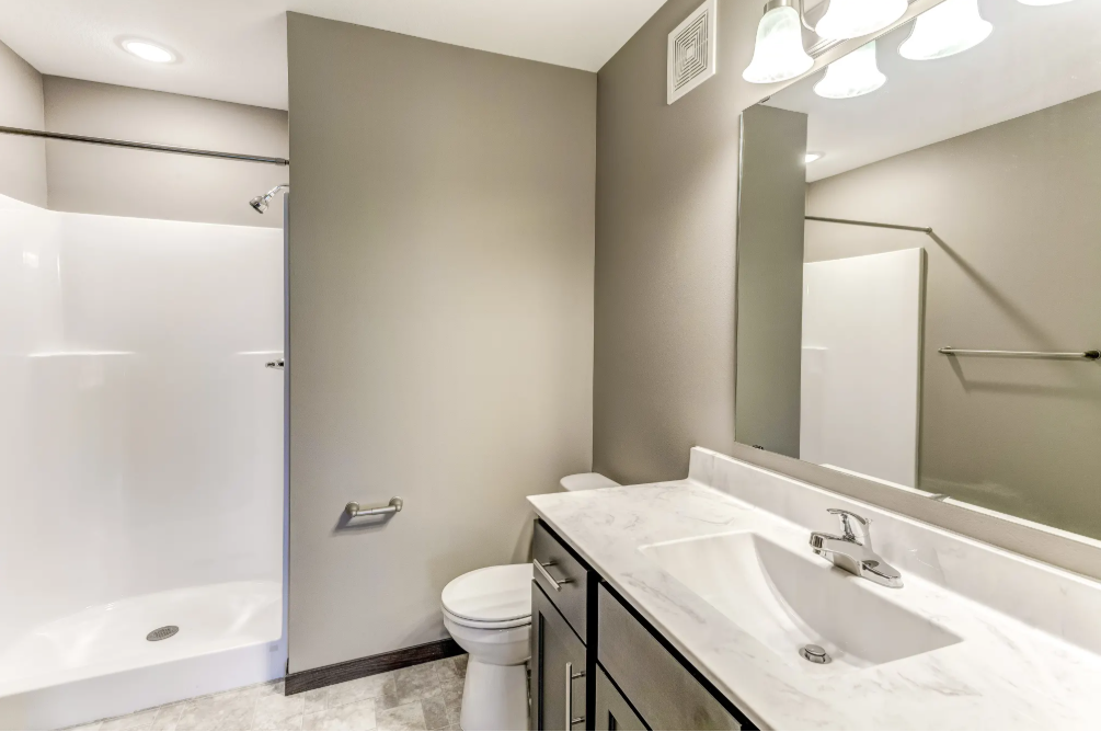 a bathroom with a large mirror and a sink and a toilet