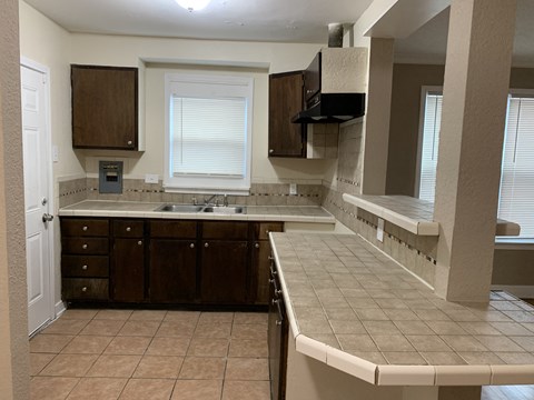 A kitchen with brown cabinets and a white counter.