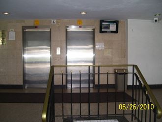 three stainless steel elevators in a lobby of a building