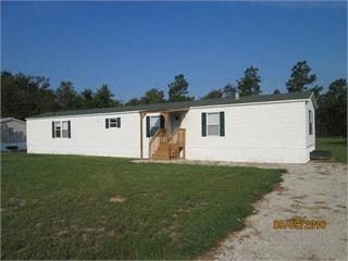 A white mobile home with a brown door and windows.