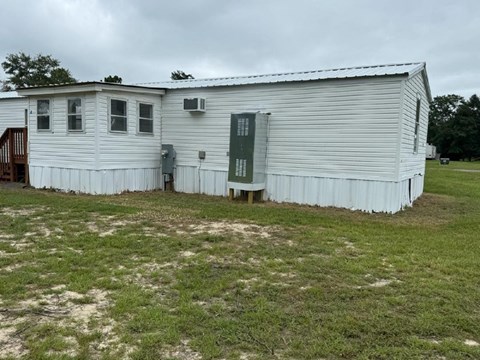 A white building with a green door and windows.