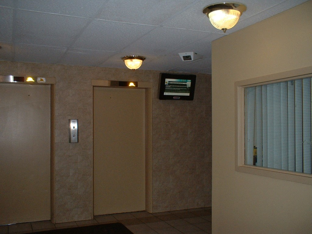 two elevators and a window and a door in a room