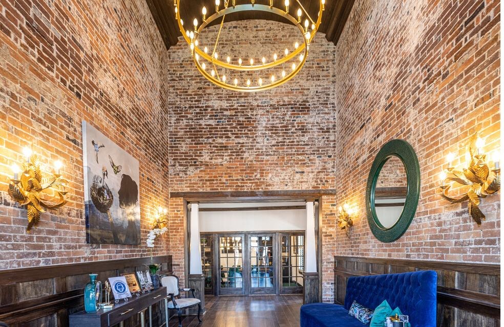 a living room with brick walls and a chandelier
