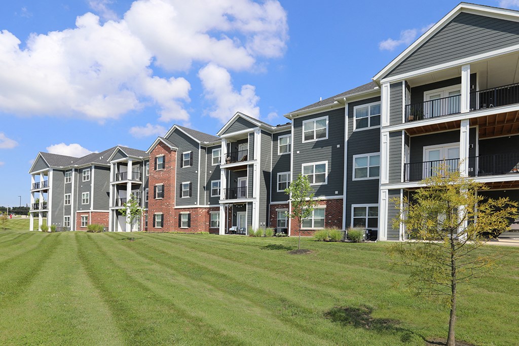 an apartment building on a green lawn