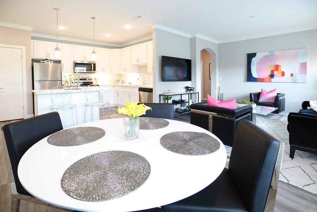 a dining room table with a vase of yellow flowers
