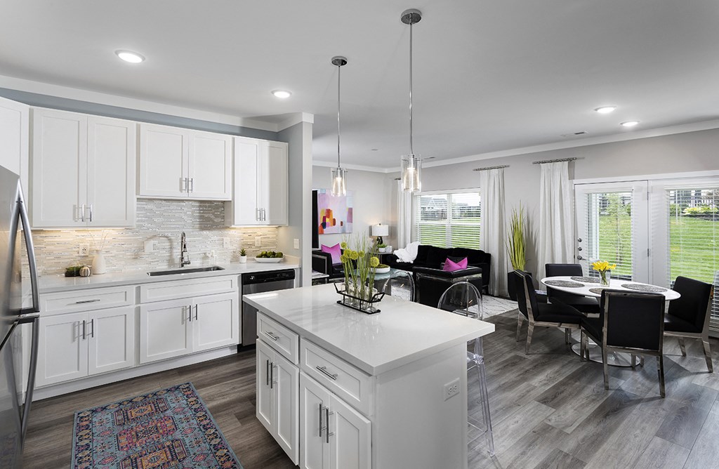 a white kitchen and living room with a table and chairs