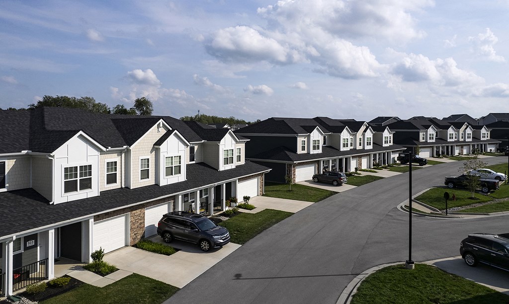 a row of houses with cars parked in front of them