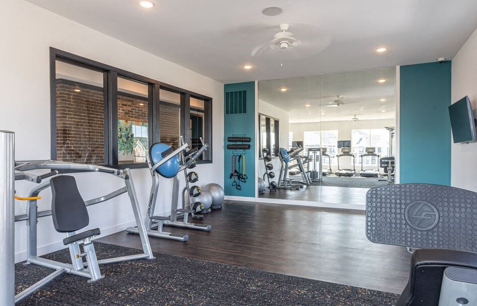 a gym with exercise equipment and windows in a building