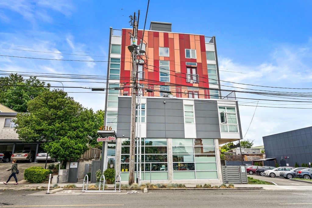 a tall building with red and green facade on a city street