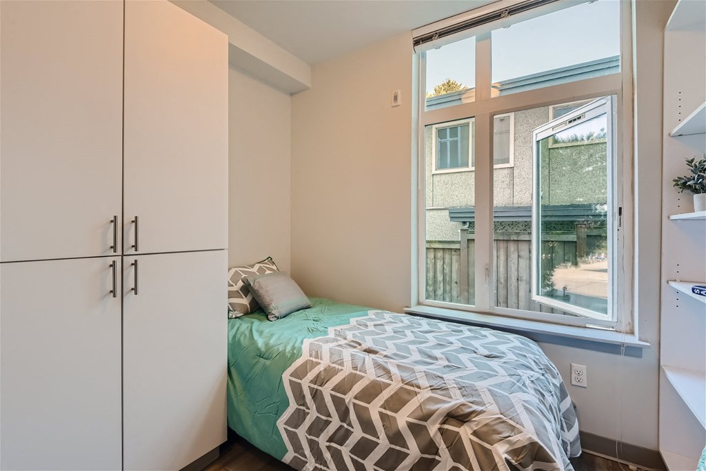 a small bedroom with a bed next to a window