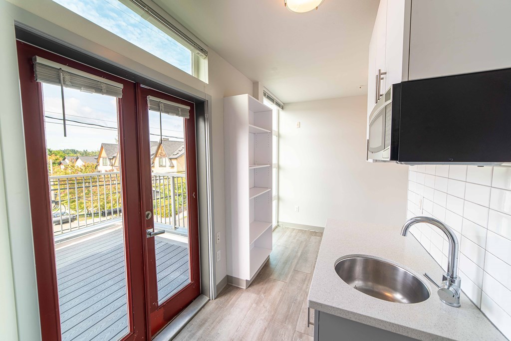 a kitchen with a sink and a door to a balcony