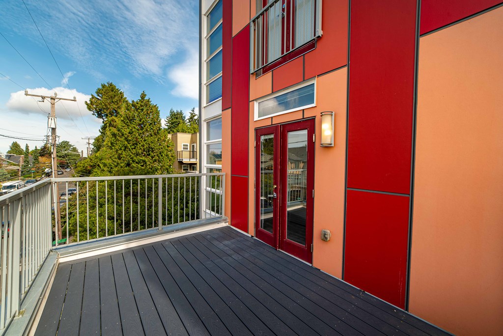 a balcony with a view of a building with red doors