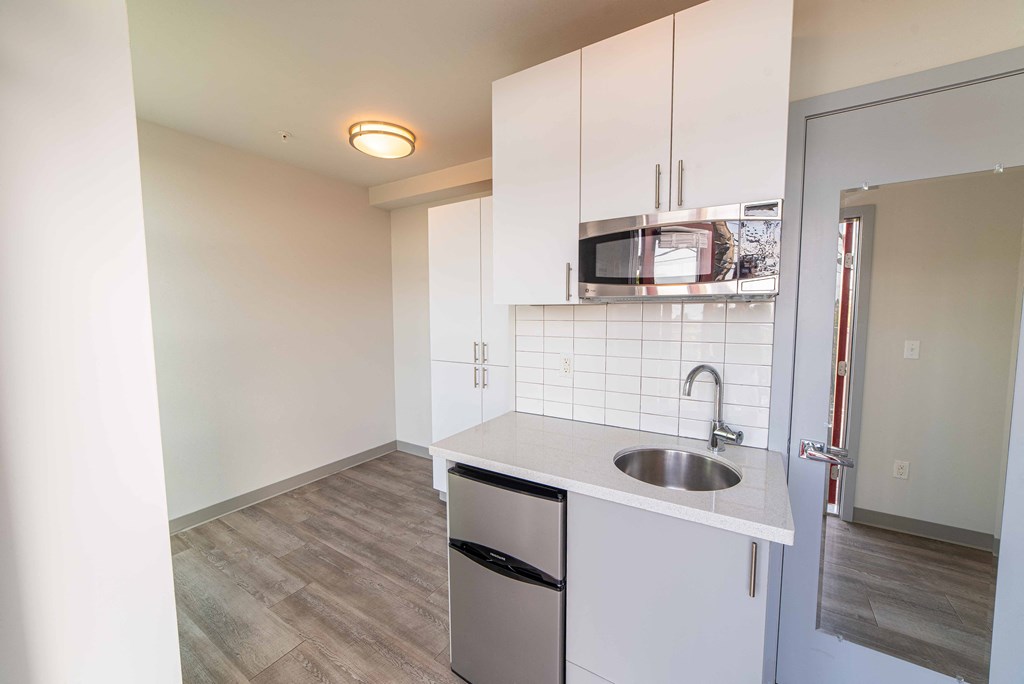 a kitchen with white cabinets and a sink and a microwave
