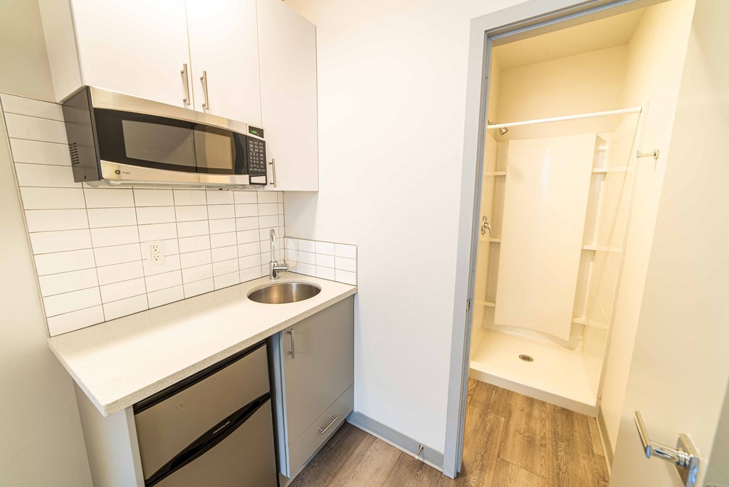 a small kitchen with a microwave and a sink