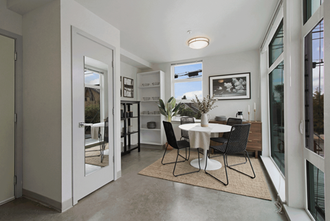A dining room with a table and chairs.