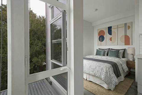 A bedroom with a bed and a painting on the wall.
