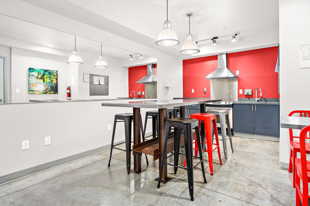 a dining area with a bar and chairs and a kitchen