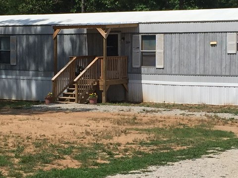 A house with a grey exterior and a wooden porch.