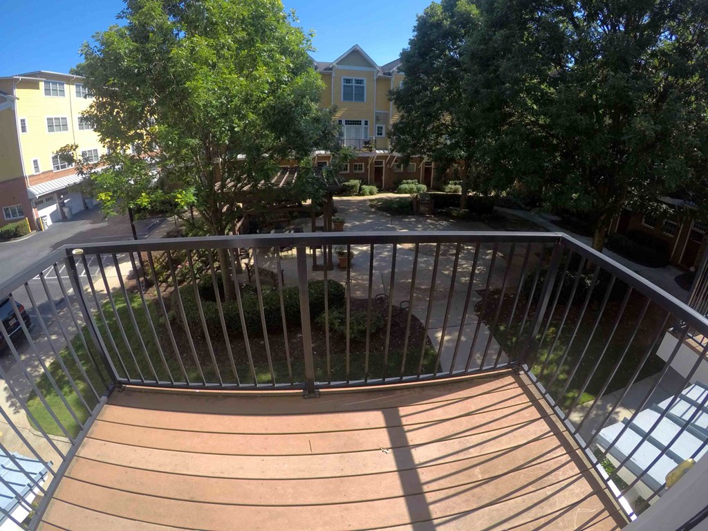 a balcony with a wooden deck and a metal railing
