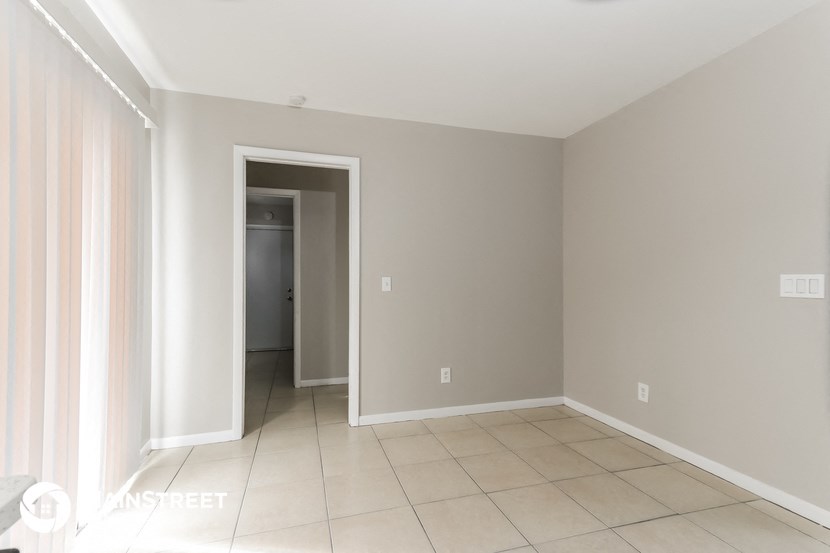 a room with a tiled floor and a door to a hallway