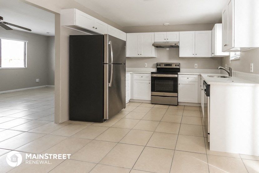a kitchen with white cabinets and stainless steel appliances